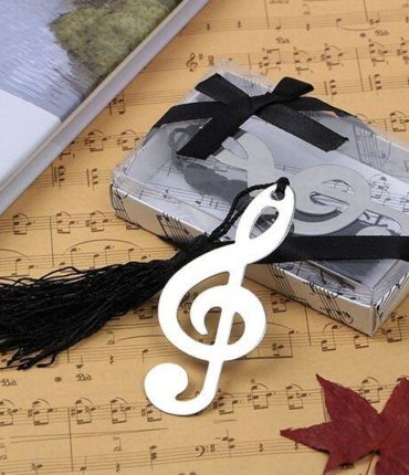 Elegante segnalibro a forma di nota musicale presentato in confezione con coperchio trasparente in pvc e fiocco di colore nero. La nota musicale è decorata con una nappina di colore nero.